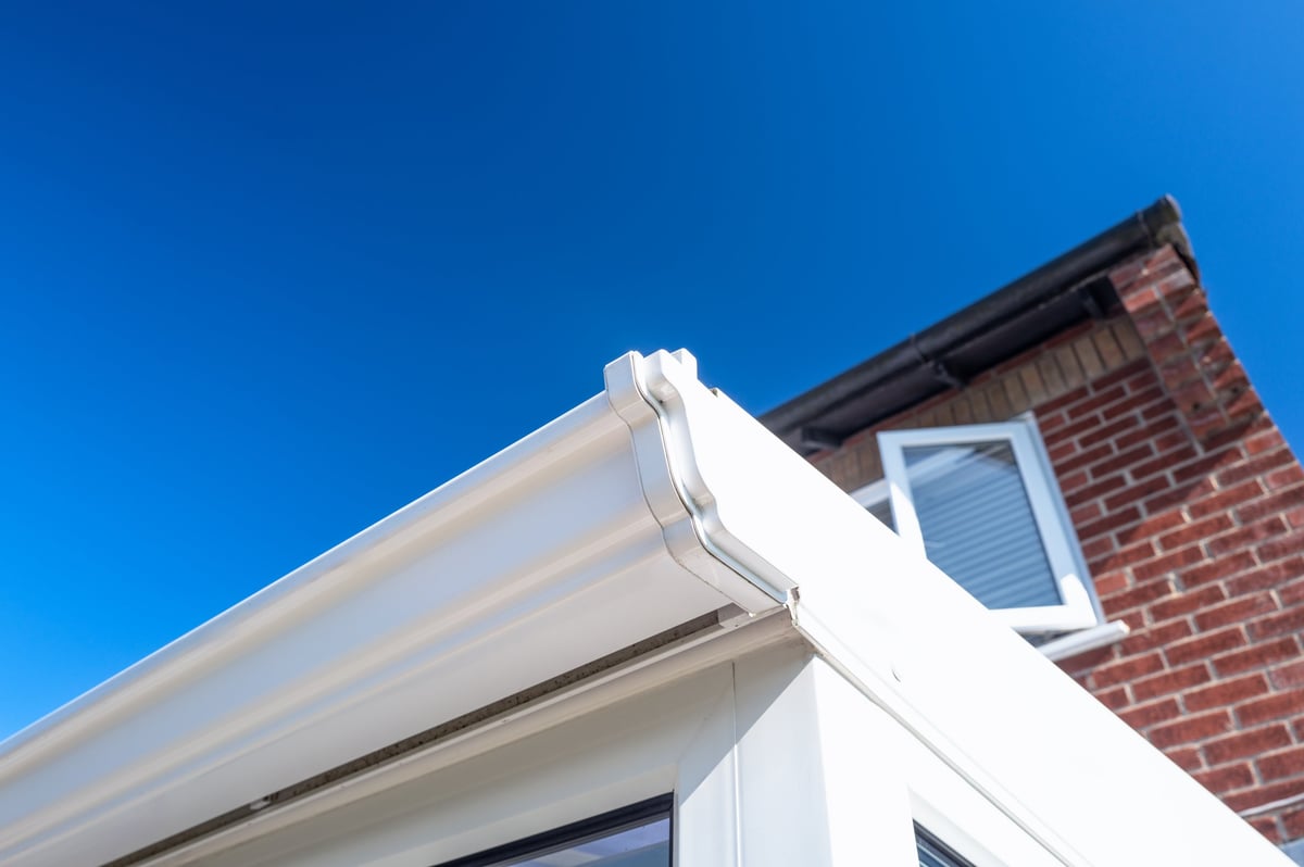 Close-up of newly replaced white plastic guttering on a conservatory