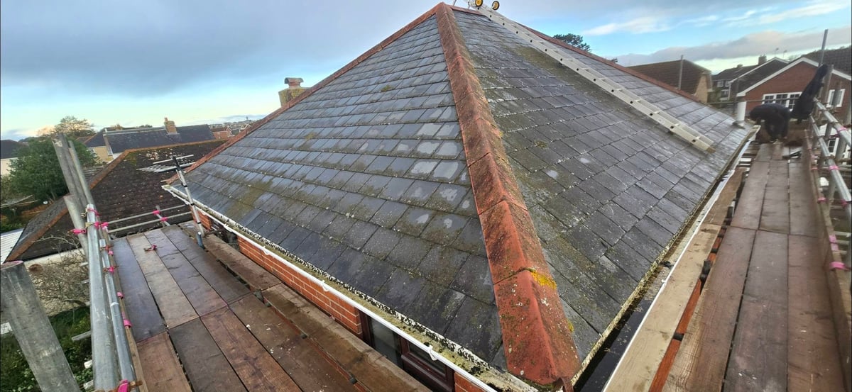 Before — aerial view of a slate roof with visible rust stains and moss growth
